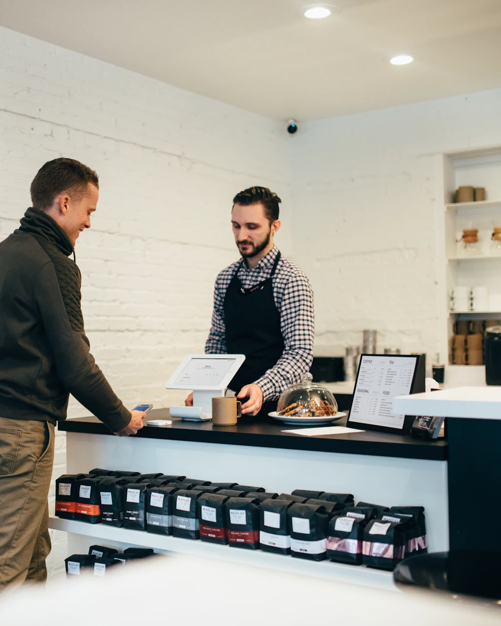 A shop owner helping a customer at the checkout counter
